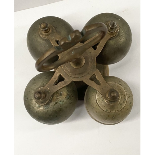 131 - AN ANTIQUE SACRISTY BELL, brass with handle, four bells, three with clappers, on circular base. Dime... 