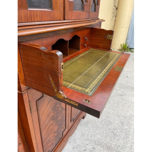 136 - A NEAT SIZED MAHOGANY BREAKFRONT BOOKCASE, with dentil cornice above four astral glazed doors reveal... 