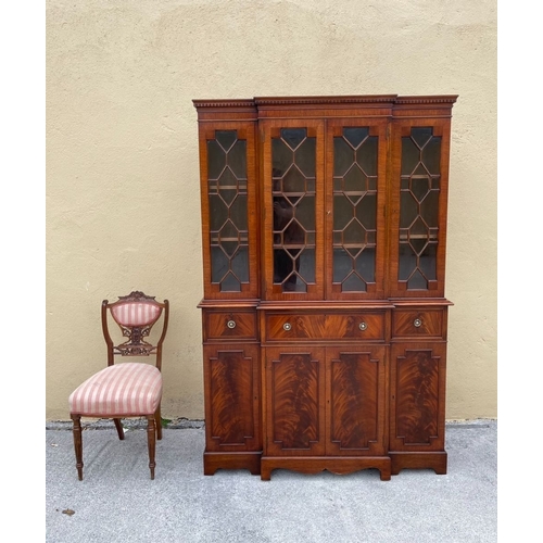 136 - A NEAT SIZED MAHOGANY BREAKFRONT BOOKCASE, with dentil cornice above four astral glazed doors reveal... 