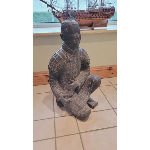 173 - A TERRACOTTA WARRIOR DECORATIVE ORNAMENTAL STATUE, in a knelling position. Dimensions: 67.5 x 32 x 2... 