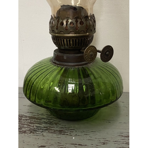 33 - A VICTORIAN GREEN GLASS DOUBLE BURNER OIL LAMP, complete with glass chimney, the double burners read... 