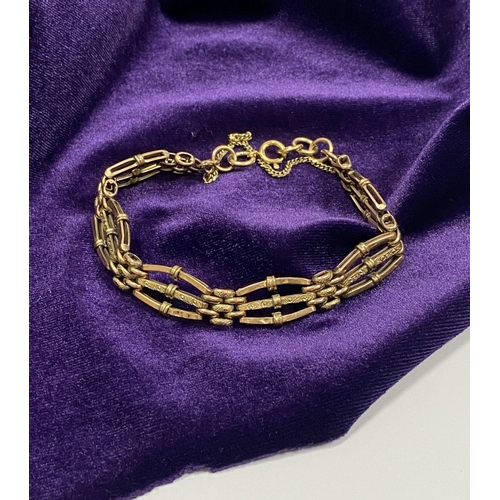 36 - A BEAUTIFUL 9CT YELLOW GOLD THREE BAR GATE BRACELET, with textured design to central bar and attachi... 