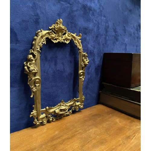 64 - A 19TH CENTURY ORNATE GILT BRONZE FRAME, neo classical with cherub mounts to sides, scrolling crest ... 