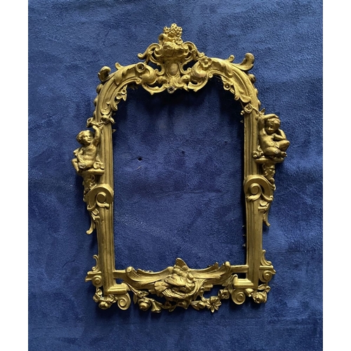 64 - A 19TH CENTURY ORNATE GILT BRONZE FRAME, neo classical with cherub mounts to sides, scrolling crest ... 