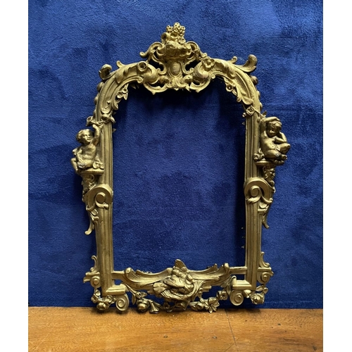 64 - A 19TH CENTURY ORNATE GILT BRONZE FRAME, neo classical with cherub mounts to sides, scrolling crest ... 