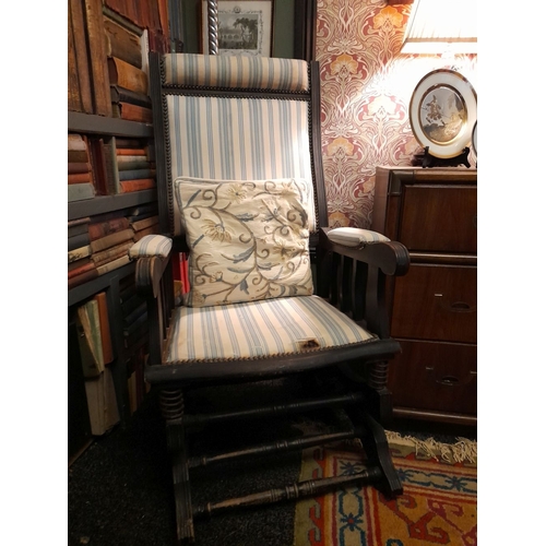 77 - AN EDWARDIAN ROCKING CHAIR, stud upholstered to headrest, backrest, armrests and seat. The supports ... 