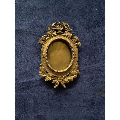 81 - A PAIR OF LATE 19TH CENTURY ORNATE BRASS MINIATURE PAINTING FRAMES, oval frame surrounded by beaded ... 