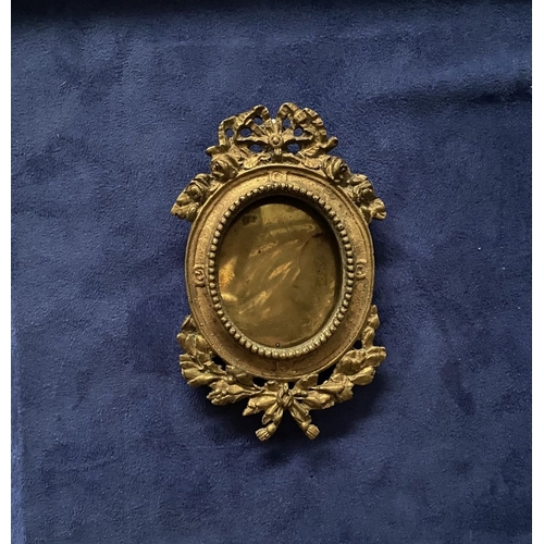 81 - A PAIR OF LATE 19TH CENTURY ORNATE BRASS MINIATURE PAINTING FRAMES, oval frame surrounded by beaded ... 