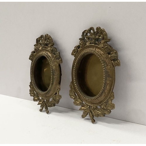 81 - A PAIR OF LATE 19TH CENTURY ORNATE BRASS MINIATURE PAINTING FRAMES, oval frame surrounded by beaded ... 