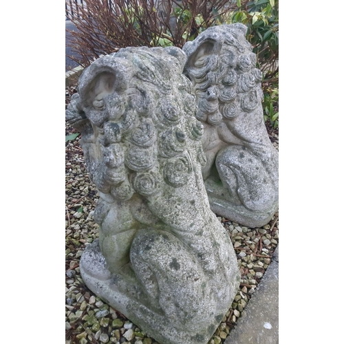 92 - A LARGE PAIR OF COMPOSITE GARDEN ORNAMENTS, in the form of Foo Dogs, detailed and very heavy, wear a... 