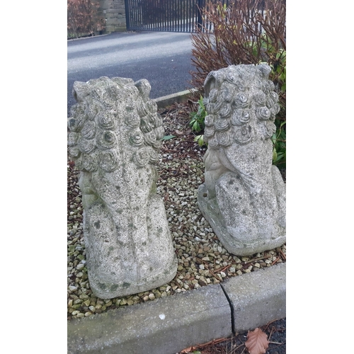 92 - A LARGE PAIR OF COMPOSITE GARDEN ORNAMENTS, in the form of Foo Dogs, detailed and very heavy, wear a... 