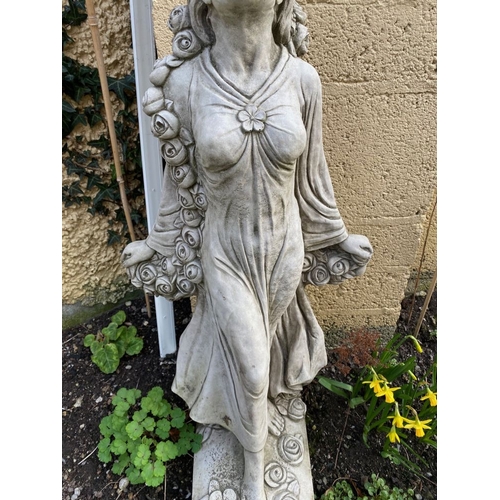 287 - A GARDEN ORNAMENT IN THE FORM OF A FEMALE FIGURE, with a rose blossom scrolling detail around her an... 