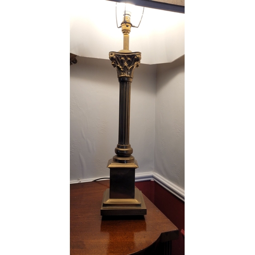 101 - A BRASS CORINTHIAN STYLE COLUMN LAMP, with shade. The base with reeded column on a raised square pla... 