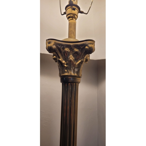 101 - A BRASS CORINTHIAN STYLE COLUMN LAMP, with shade. The base with reeded column on a raised square pla... 