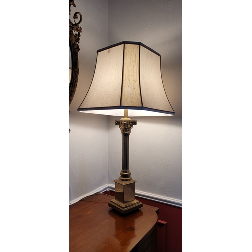 101 - A BRASS CORINTHIAN STYLE COLUMN LAMP, with shade. The base with reeded column on a raised square pla... 