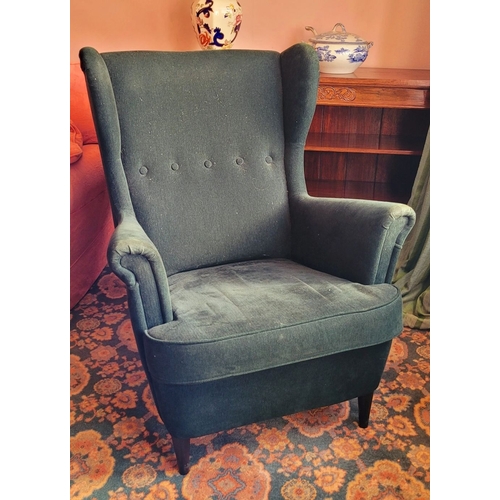 103 - A VERY GOOD CONTEMPORARY WING BACKED ARMCHAIR, in a green upholstery with button detail to the back,... 