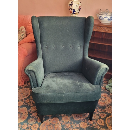 103 - A VERY GOOD CONTEMPORARY WING BACKED ARMCHAIR, in a green upholstery with button detail to the back,... 