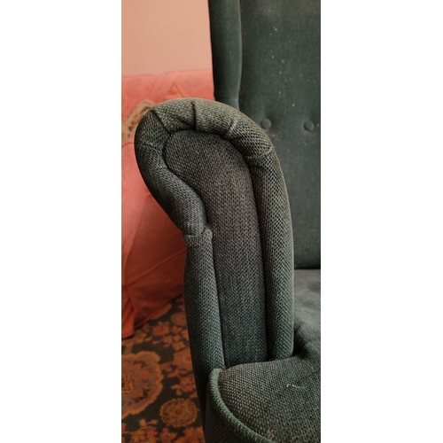 103 - A VERY GOOD CONTEMPORARY WING BACKED ARMCHAIR, in a green upholstery with button detail to the back,... 