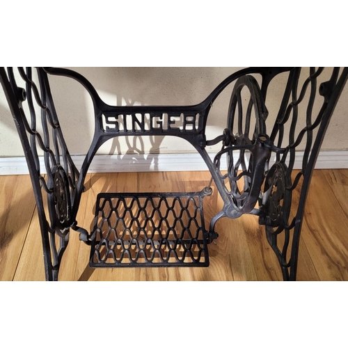 118 - A PINE TOPPED SINGER SEWING MACHINE BASED TABLE, the cast metal base with ‘SINGER’ lettering to the ... 