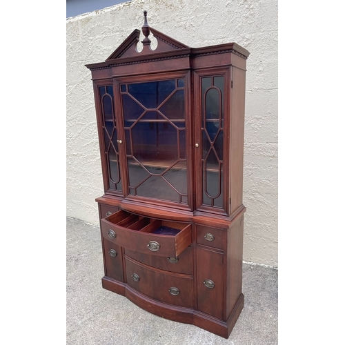 12 - A NEAT SIZED MAHOGANY BOW FRONTED BOOKCASE, with carved pediment to top above three architectural gl... 