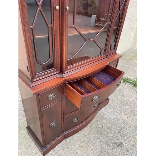 12 - A NEAT SIZED MAHOGANY BOW FRONTED BOOKCASE, with carved pediment to top above three architectural gl... 