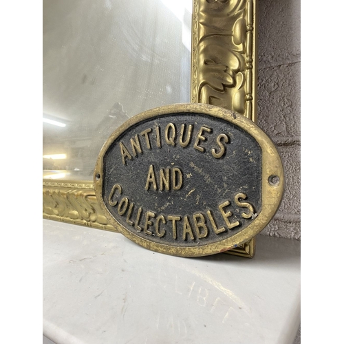 135 - A HEAVY VINTAGE BRASS SIGN, oval form, reading ‘Antiques and Collectables’. Dimensions: 29cm wide x ... 