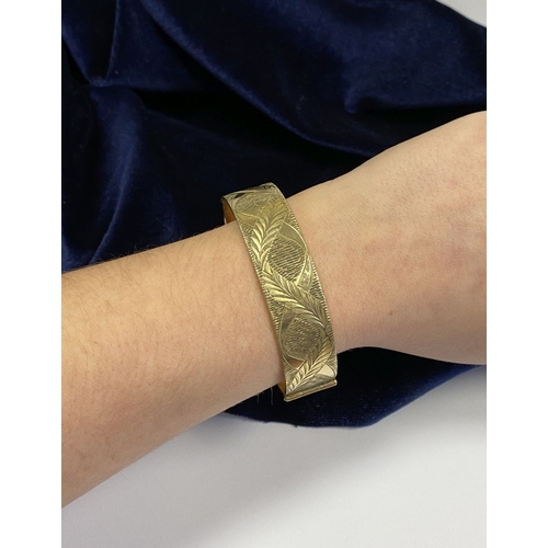 148 - A BEAUTIFUL VINTAGE 9CT ROLLED GOLD BANGLE BRACELET, the front with   delicate etched leaf pattern, ... 