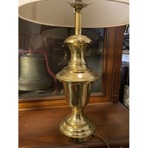 190 - A PAIR OF BRASS TABLE LAMPS, with turned supports on circular platform bases, complete with cream la... 