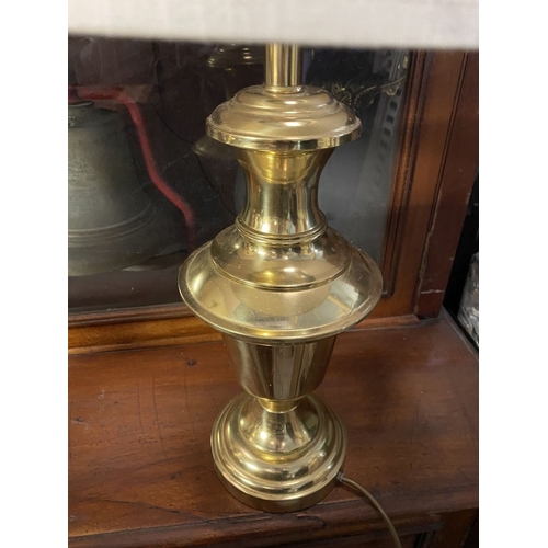 190 - A PAIR OF BRASS TABLE LAMPS, with turned supports on circular platform bases, complete with cream la... 