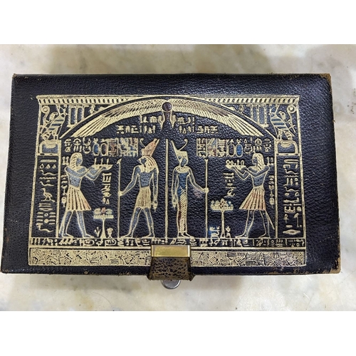 208 - A VINTAGE LEATHER MUSIC JEWELLERY BOX, the top embossed with Egyptian motifs with gilt outline, the ... 