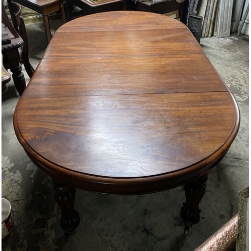 221 - A FINE MAHOGANY D-END EXTENDING DINING TABLE, raised on turned fluted leg on brass castors. Dimensio... 