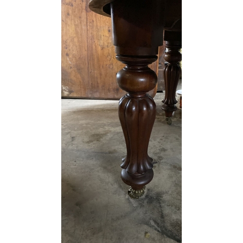 221 - A FINE MAHOGANY D-END EXTENDING DINING TABLE, raised on turned fluted leg on brass castors. Dimensio... 