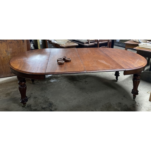 221 - A FINE MAHOGANY D-END EXTENDING DINING TABLE, raised on turned fluted leg on brass castors. Dimensio... 