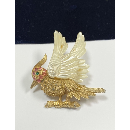 257 - A VINTAGE GOLD TONE CARVED CELLULOID WINGS BIRD BROOCH, finely decorated, with multi tone gemstones ... 