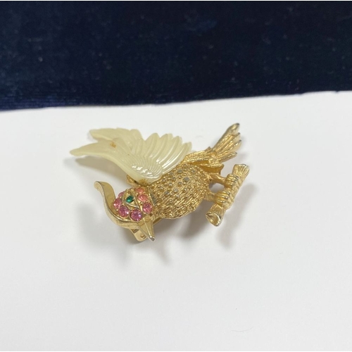 257 - A VINTAGE GOLD TONE CARVED CELLULOID WINGS BIRD BROOCH, finely decorated, with multi tone gemstones ... 