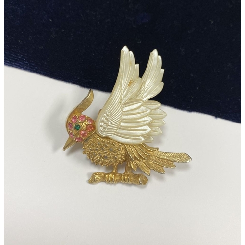 257 - A VINTAGE GOLD TONE CARVED CELLULOID WINGS BIRD BROOCH, finely decorated, with multi tone gemstones ... 