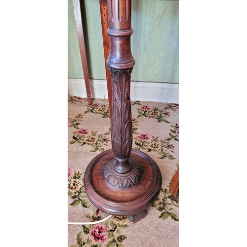 262 - A TALL WOODEN STANDARD LAMP, with lovely foliage carved detail to the end of the fluted column, on a... 