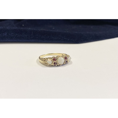 319 - A LOVELY 9CT YELLOW GOLD OPAL & GARNET RING, set with three round cut vibrant opals, four round cut ... 