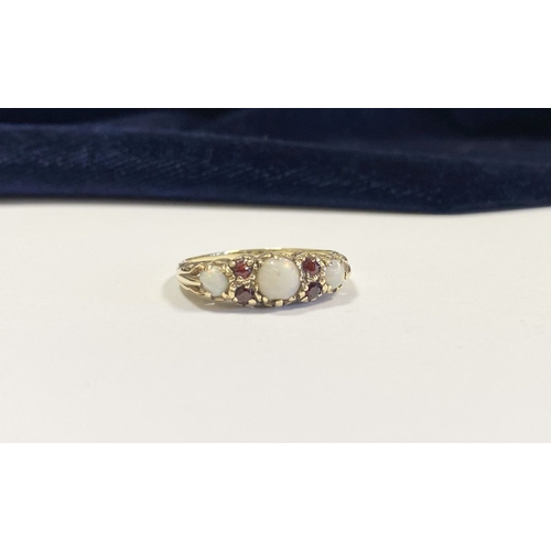 319 - A LOVELY 9CT YELLOW GOLD OPAL & GARNET RING, set with three round cut vibrant opals, four round cut ... 