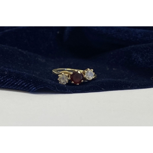 320 - A 9CT YELLOW GOLD GARNET THREE STONE RING, with round cut central garnet in raised claw setting, fla... 