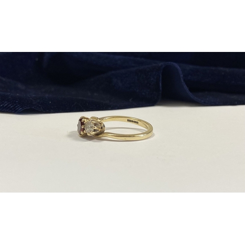 320 - A 9CT YELLOW GOLD GARNET THREE STONE RING, with round cut central garnet in raised claw setting, fla... 