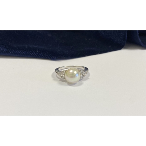 321 - A STERLING SILVER PEARL & CLEAR GEMSTONE RING, central large pearl, flanked by six clear round cut g... 