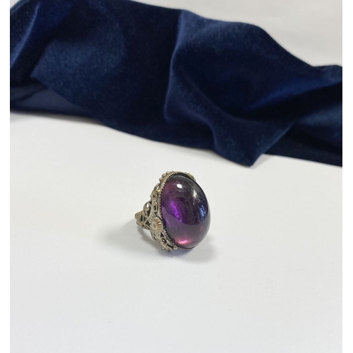 323 - A BEAUTIFUL LARGE OVAL CABOCHON CUT POLISHED CENTRE STONE RING, mounted in highly decorative silver ... 