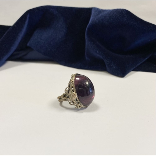 323 - A BEAUTIFUL LARGE OVAL CABOCHON CUT POLISHED CENTRE STONE RING, mounted in highly decorative silver ... 