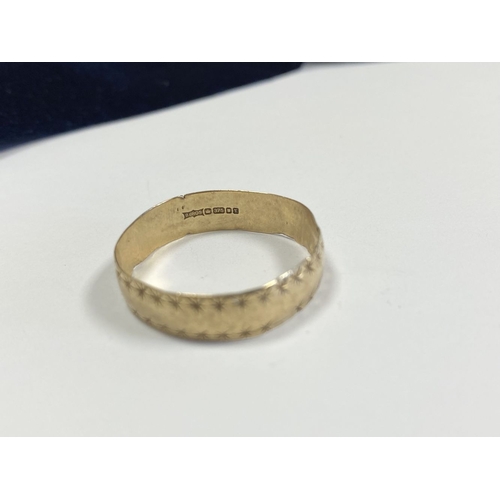 324 - A 9CT YELLOW GOLD BAND RING, engraved to exterior with two rows of stars, hallmarked to interior ban... 