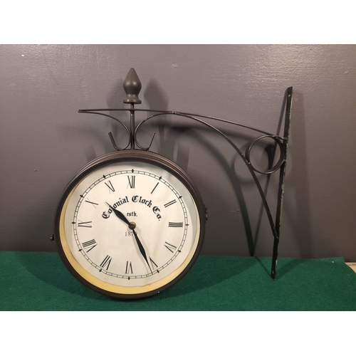 327 - A DOUBLE SIDED METAL WALL HANGING CLOCK, by Colonial Clock Co, Estb. 1870, in working order. Bracket... 