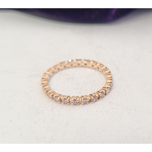 341 - A PRETTY SPARKLING ROSE GOLD DIAMOND ETERNITY RING, with round brilliant cut diamonds running along ... 