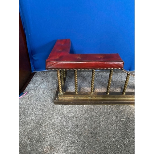 360 - A GOOD SIZED BRASS CLUB FENDER, with red leather button upholstered seats, twist design to supports ... 