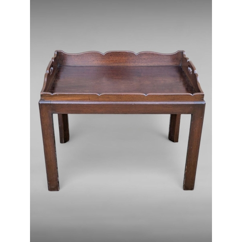 48 - A FINE GEORGIAN STYLE MAHOGANY BUTLER’S TRAY ON STAND, the tray with raised shaped gallery, with cut... 