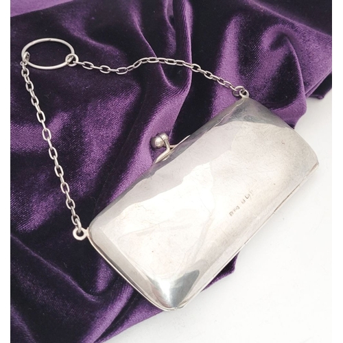 65 - AN EARLY 20TH CENTURY SILVER CLUTCH PURSE, the rounded rectangular silver body has a ball clasp that... 